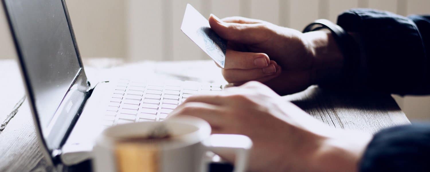 Pay-Per-Click Marketing | Man Holding Credit Card at Laptop