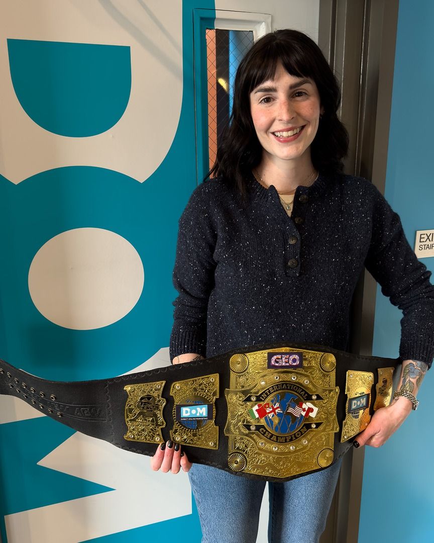 SEO/GEO Strategist holding the DOM GEO belt, generative engine optimization services